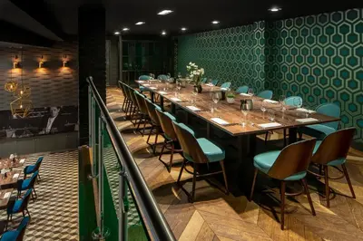 a long table in a restaurant with blue chairs at Hotel Indigo Liverpool by IHG in Liverpool