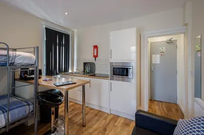 a small room with a kitchen and a bunk bed at Seaside Suites Superior Family Apartments in Blackpool
