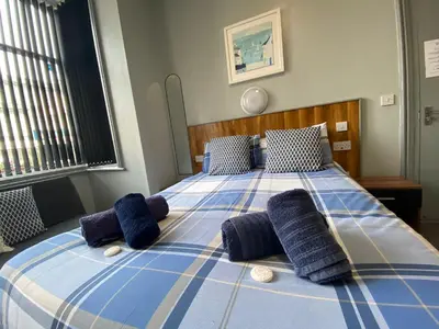a blue and white bed with blue pillows on it at Seaside Suites Superior Family Apartments in Blackpool