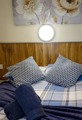 a bed with blue and white pillows on it at Seaside Suites Superior Family Apartments in Blackpool