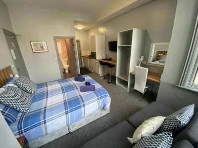 a bedroom with a bed and a desk and a couch at Seaside Suites Superior Family Apartments in Blackpool