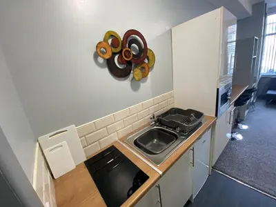 a small kitchen with a sink and a counter at Seaside Suites Superior Family Apartments in Blackpool