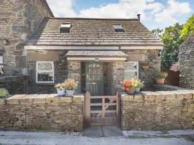 a stone house with a gate in front of it at Thimble Cottage in Ulverston
