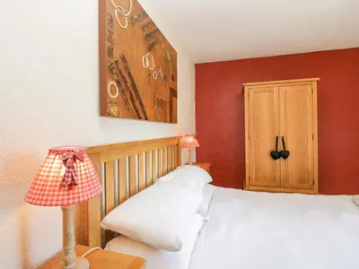a bedroom with a white bed and red walls at Beech Cottage in Ulverston
