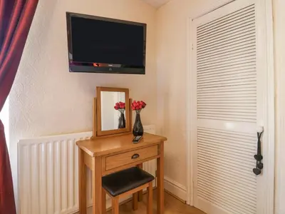 a room with a table with a mirror and a mirror at Beech Cottage in Ulverston