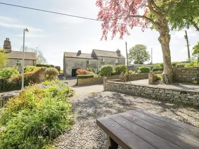 a wooden bench in the garden of a house at Beech Cottage in Ulverston
