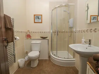 a bathroom with a toilet and a shower and a sink at Woodside Barn in Ulverston