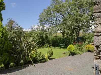 a garden with plants and a stone wall at Woodside Barn in Ulverston