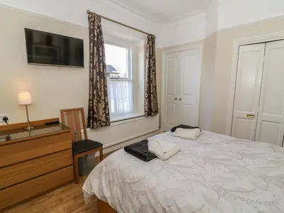 a bedroom with a bed and a tv and a window at Riverside View in Grange Over Sands