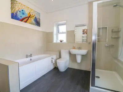 a bathroom with a tub and a toilet and a sink at Riverside View in Grange Over Sands