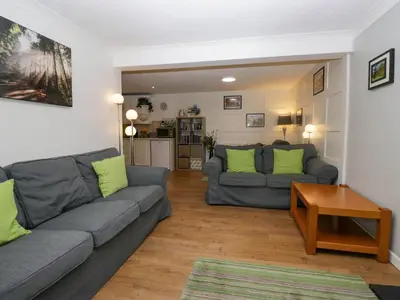 a living room with two couches and a table at The Old Mill in Grange Over Sands