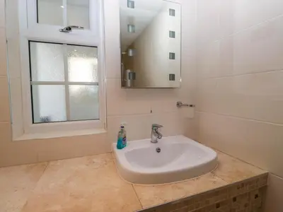 a white sink in a bathroom with a mirror at The Old Mill in Grange Over Sands