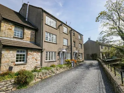 a cobblestone street in front of an old stone building at The Old Mill in Grange Over Sands