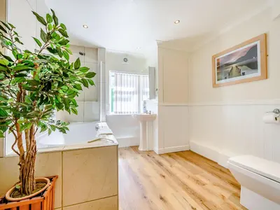 a bathroom with a white tub and a sink at Eden House in Ulverston