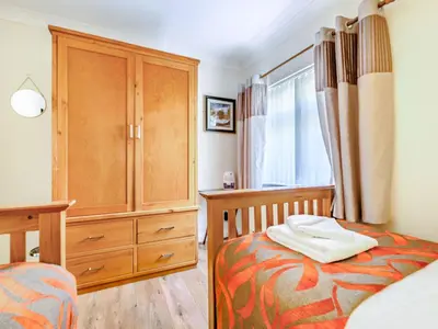 a bedroom with a bed and a wooden dresser at Eden House in Ulverston