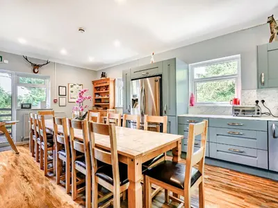 a kitchen and dining room with a wooden table and chairs at Eden House in Ulverston