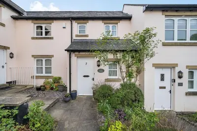 a white house with a white garage at Amber Cottage in Holker