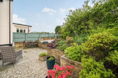 a garden with plants and flowers on a patio at Amber Cottage in Holker
