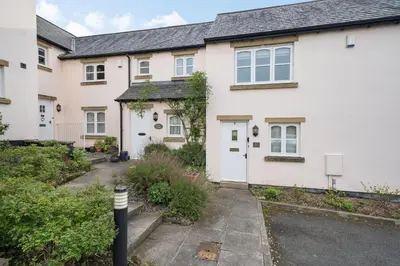 a white house with a driveway in front of it at Amber Cottage in Holker