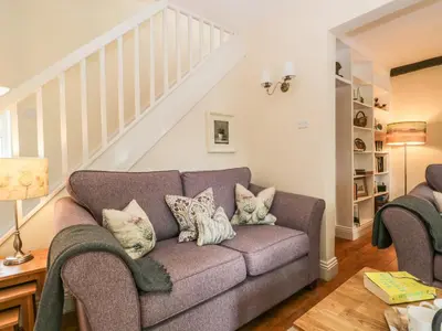 a living room with a couch with pillows at Mulberry Cottage in Grange Over Sands