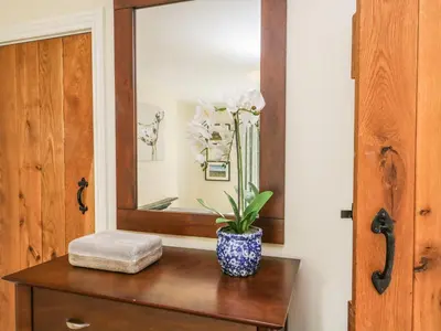 a bathroom with a mirror and a table with a plant at Mulberry Cottage in Grange Over Sands