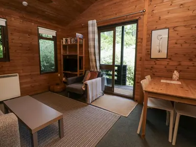 a living room of a log cabin with a table and chairs at Buttermere in Ulverston