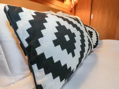 a black and white pillow sitting on a bed at Buttermere in Ulverston
