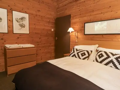 a bedroom with a bed and a wooden wall at Buttermere in Ulverston