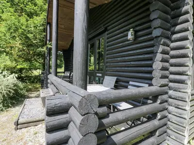 a log cabin with a bench on the porch at Grasmere in Ulverston