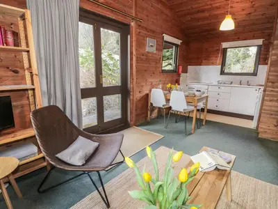 a living room with a table and chairs and a kitchen at Grasmere in Ulverston