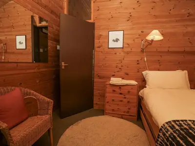 a bedroom with a bed and a chair and a lamp at Grasmere in Ulverston