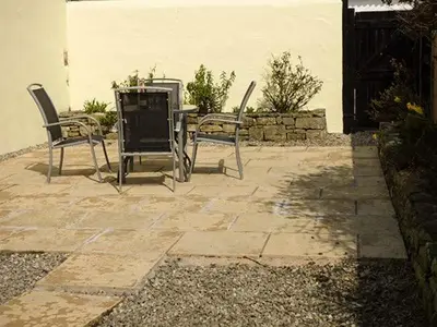 two chairs and a table on a patio at The Byre in Grange Over Sands
