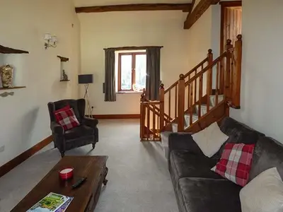 a living room with a couch and a table at The Byre in Grange Over Sands