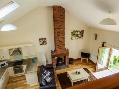 a living room with a fireplace and a couch at Poppy Cottage in Lancaster