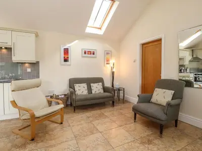 a living room with three chairs and a table at Stable Cottage in Burton in Lonsdale