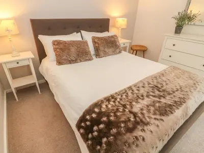 a bedroom with a large white bed with two pillows at The Potting Shed in Carnforth