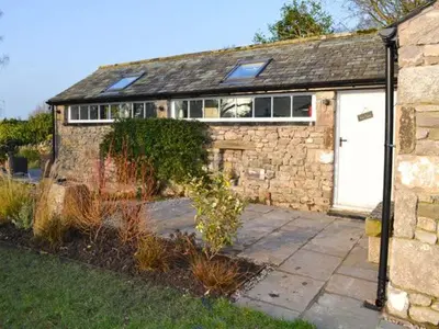 a brick house with a white door and a window at The Potting Shed in Carnforth