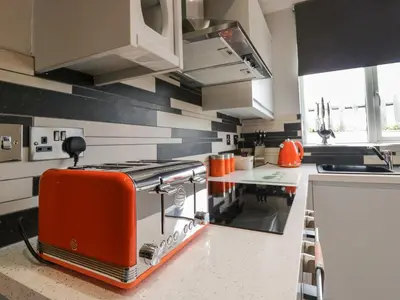 a kitchen with an orange toaster sitting on a counter at Bluebell Cottage in Ulverston