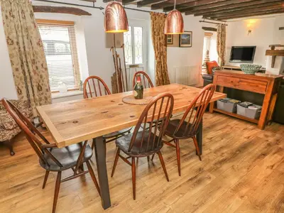 a dining room with a wooden table and chairs at Rosemary Cottage in Carnforth