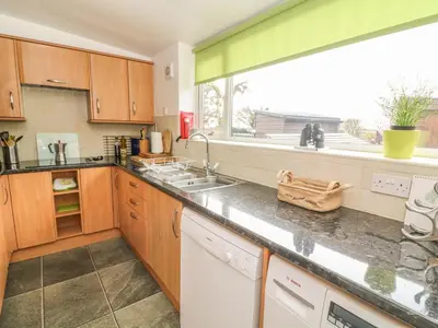 a kitchen with a sink and a large window at Rosemary Cottage in Carnforth
