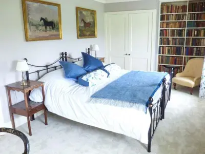 a bedroom with a large bed with blue pillows at The Old Forge in Waddington