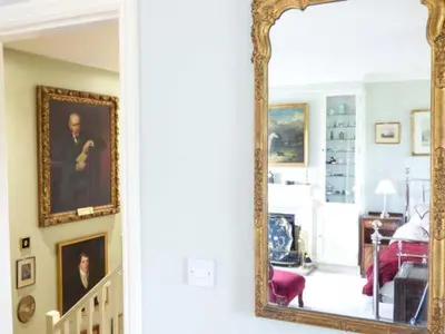 a mirror in a room with portraits on the wall at The Old Forge in Waddington