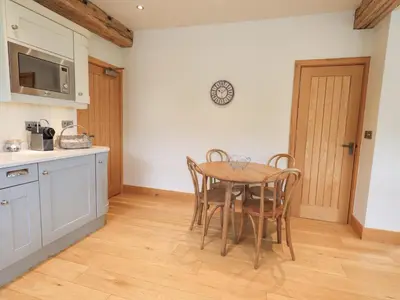 a kitchen with a table and chairs in a room at Hazel Cottage in Ulverston