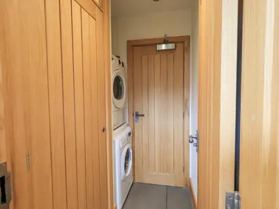 a laundry room with a washing machine and a washer at Hazel Cottage in Ulverston