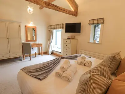 a bedroom with a bed with towels on it at Hazel Cottage in Ulverston