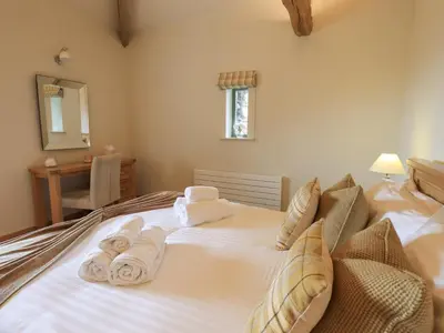a bedroom with a bed with towels on it at Hazel Cottage in Ulverston