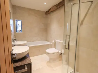 a bathroom with a toilet and a sink and a shower at Hazel Cottage in Ulverston