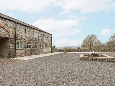 an external view of a stone building with a driveway at Hazel Cottage in Ulverston