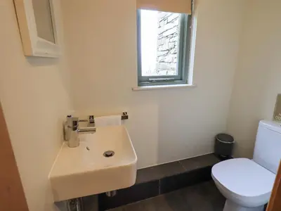 a bathroom with a sink and a toilet at Keepers Cottage in Ulverston