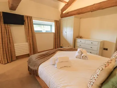 a bedroom with a bed with towels on it at Keepers Cottage in Ulverston